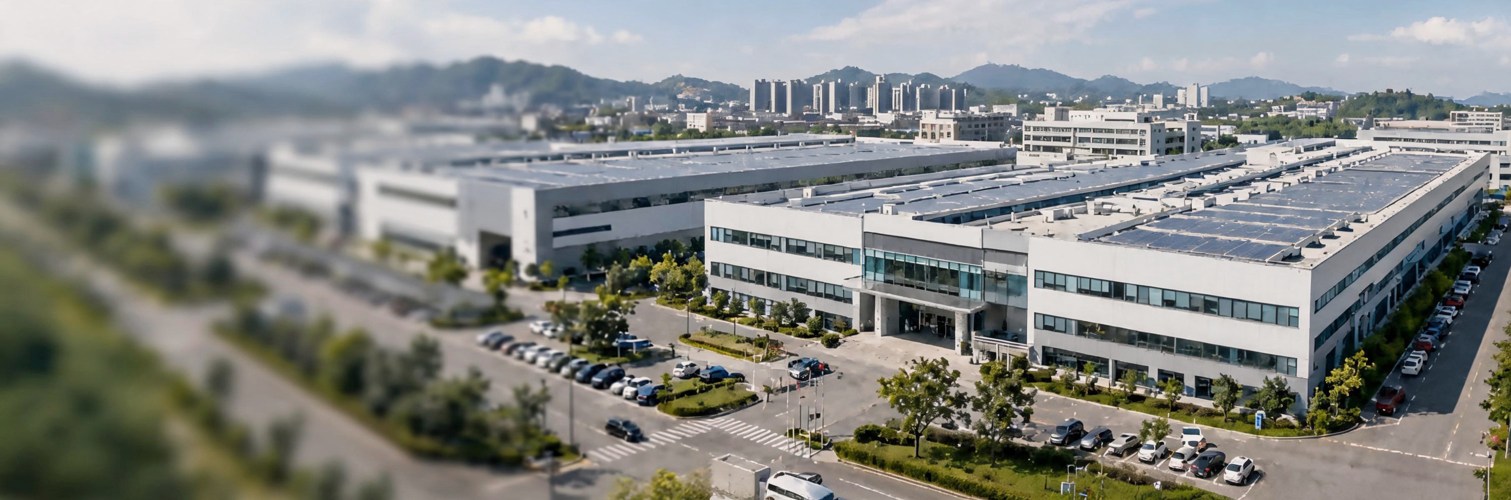 Aerial view of a modern industrial campus with factory buildings and landscaped grounds.